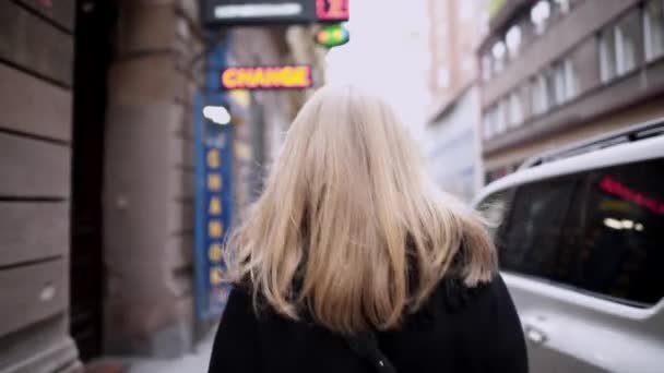 Gimbal shot of back of woman walking on european street - Πλάνα, βίντεο