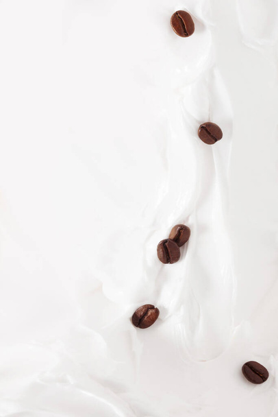 Coffee milk dessert. Coffee beans among yogurt or milk. - Photo, Image