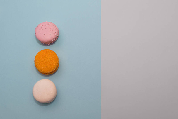 Three multi-colored macaroon on flat background. Picture with copy space - 写真・画像