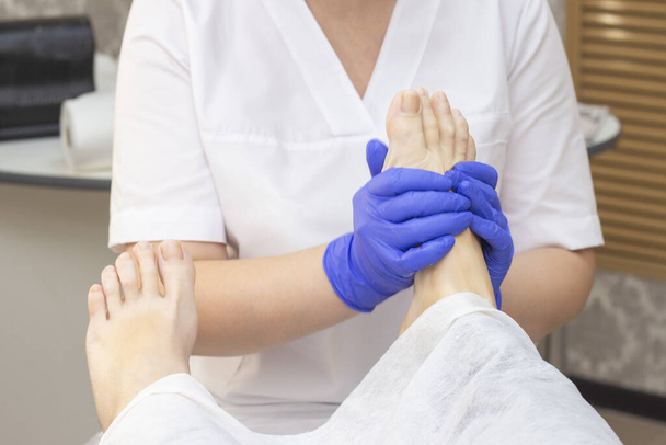 Foot massage in spa salon, closeup. foot massage relax skin care. Therapeutic pedicure. - Foto, Imagen