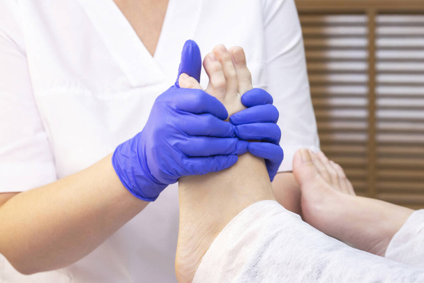 Foot massage in spa salon, closeup. foot massage relax skin care. Therapeutic pedicure. - Photo, image