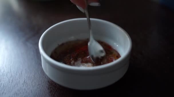 stir the sauce in a bowl with a spoon - Filmati, video