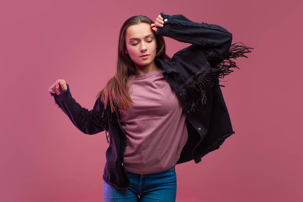 Young brunette woman on pink background. Studio portrait, informal style of clothing, - Фото, зображення
