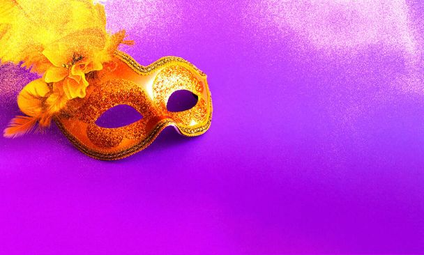 Маска Золотого карнавала на фиолетовом фоне с блестками. Размытый эффект. Концепция Марди Гра. Копирование пространства, крупным планом
 - Фото, изображение