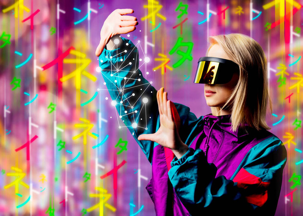 Blonde in VR glasses and 90s sport suit with Japanese hieroglyphs aroud - Foto, afbeelding