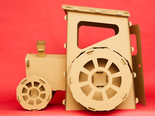 The cardboard tractor on red background. Agricultural and eco concept - Foto, immagini