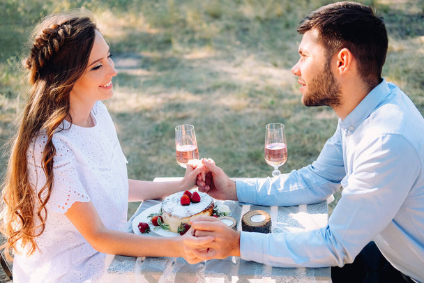 Ζευγάρι εραστές σε μια ημερομηνία γιορτάζει τον αρραβώνα τους στο τραπέζι του δείπνου σε εξωτερικούς χώρους - Italian restaurant terasse - Φωτογραφία, εικόνα