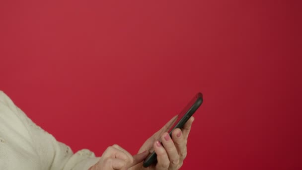 Cropped view of senior woman scrolling and typing on smartphone - Footage, Video