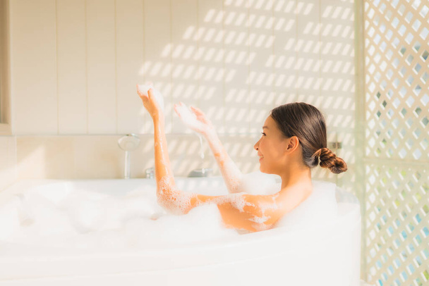 Portrait young asian woman relax take a bath in bathtub for spa concept - Photo, Image