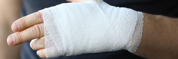 Mão masculina com bandagem elástica apertada no braço closeup
 - Foto, Imagem