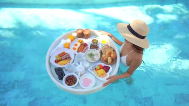footage of beautiful Asian woman relaxing in pool at hotel - Felvétel, videó