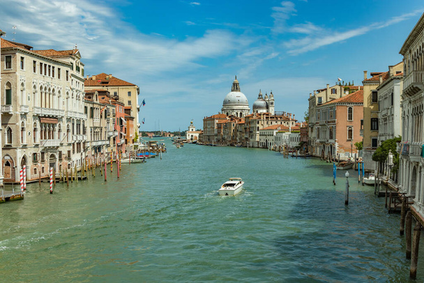 VENICE, ITALY - August 02, 2019: Grand Canal with Basilica di Santa Maria della Salute in Venice, Italy. View of Venice Grand Canal in sunny day. Architecture and landmarks of Venice. - Φωτογραφία, εικόνα