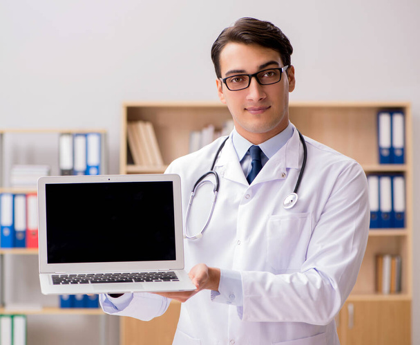 Молодой врач с ноутбуком - Фото, изображение