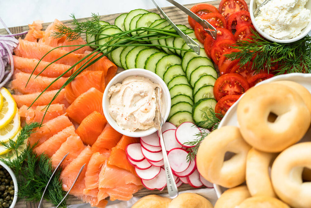 Mesa de almuerzo Bagel con salmón ahumado y verduras frescas
. - Foto, Imagen