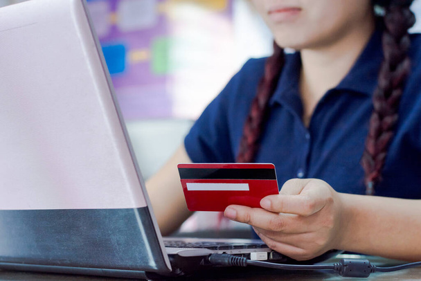 Mulher mão segurando cartão de crédito e usando computador portátil. Conceito de compras online - Foto, Imagem