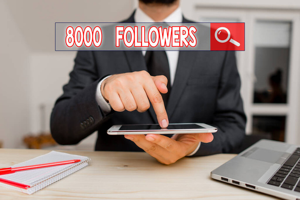 Handwriting text 8000 Followers. Concept meaning number of individuals who follows someone in Instagram Male human wear formal clothes present presentation use hi tech smartphone. - Photo, Image