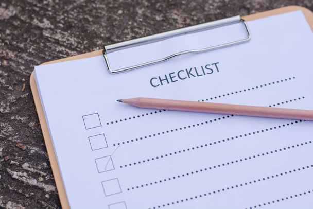 Concetto di checklist - checklist, carta e penna con la parola checklist sul pavimento in cemento
 - Foto, immagini