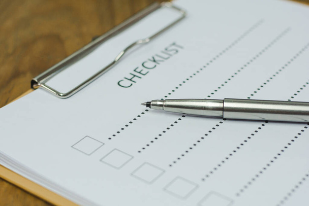 Концепция контрольного списка - контрольный список, бумага и ручка со словом контрольного списка на деревянном столе
 - Фото, изображение