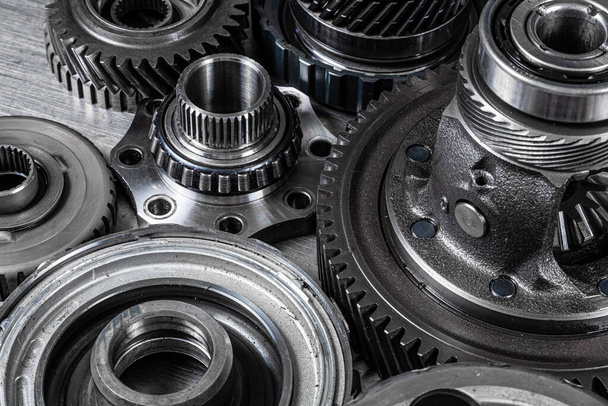 Set of various engine and gearbox spare parts. Shiny gears for planetary gearbox.Metal  autotechnology background. wheel engine gears, close up - 写真・画像