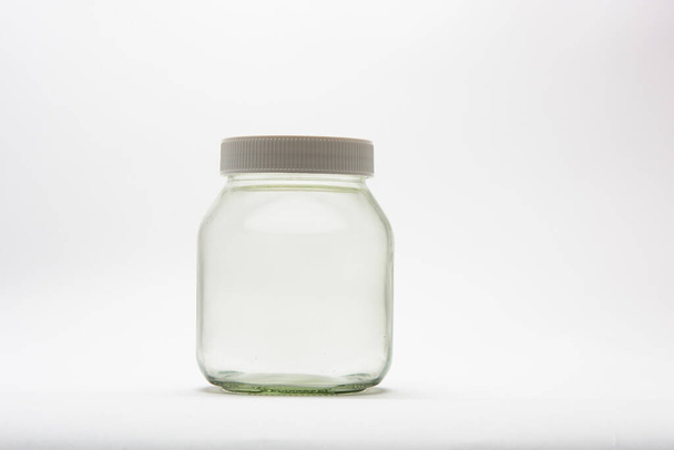 Empty glass jar lit in a studio with white background. - Photo, Image