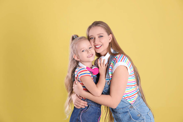 Happy mother and little daughter on yellow background - Fotoğraf, Görsel