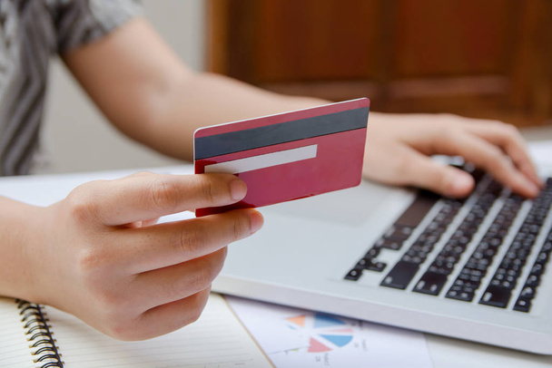 женщина, использующая ноутбук и держащая кредитную карту в интернет-магазинах или интернет-банкинге
. - Фото, изображение