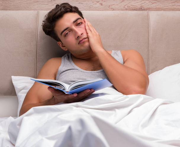 Homme lisant le livre dans le lit
 - Photo, image