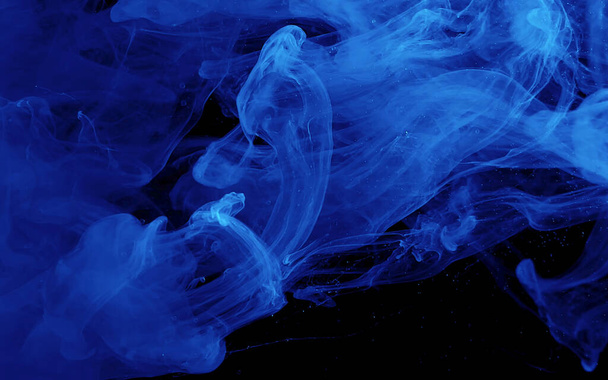 Blue watercolor ink in water on a black background. Colored space background. Abstract background. Stylish trending screensaver. - Fotografie, Obrázek