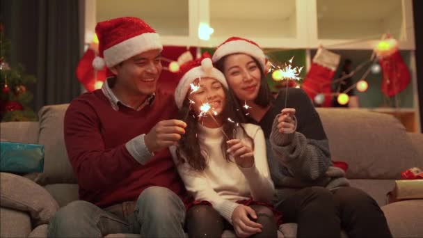 Slow motion video shooting of a happy family living all together of father Mother and daughter playing fun fireworks on Christmas day. - Video, Çekim