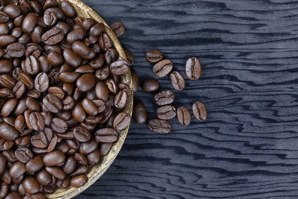 Coffee beans in a wooden plate on a wood grain background detail food art - Photo, Image