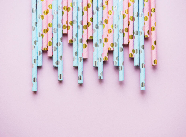 Питьевые пунктирные соломинки для вечеринки на розовом фоне с копировальным пространством. Вид сверху цветной бумаги одноразовые экологически чистые соломинки для летних коктейлей
. - Фото, изображение