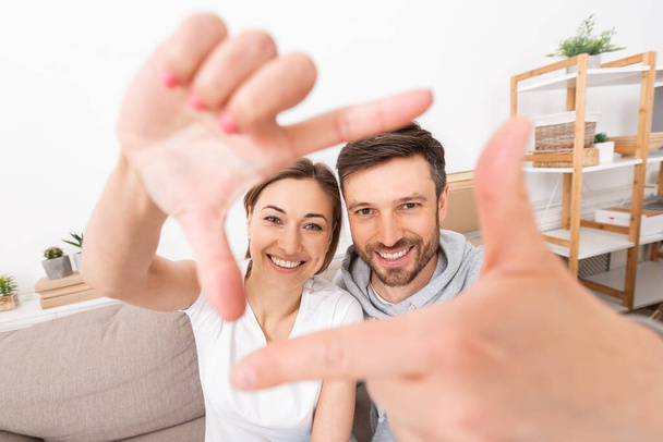 Casal feliz tomando selfie com gesto de moldura de mão
 - Foto, Imagem