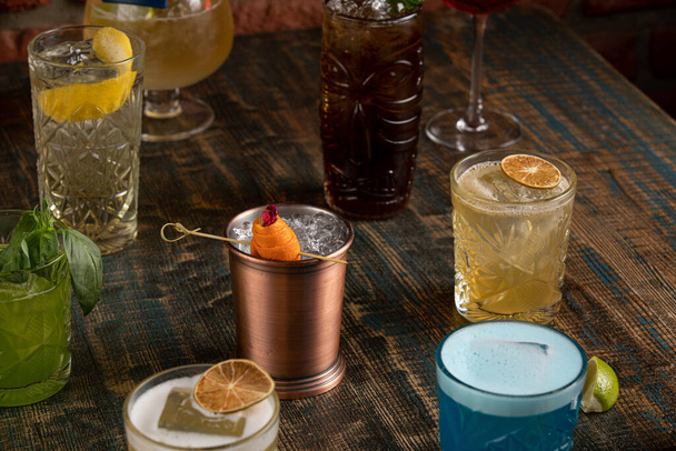 De nombreux cocktails de différentes couleurs sur une table en bois rustique
 - Photo, image