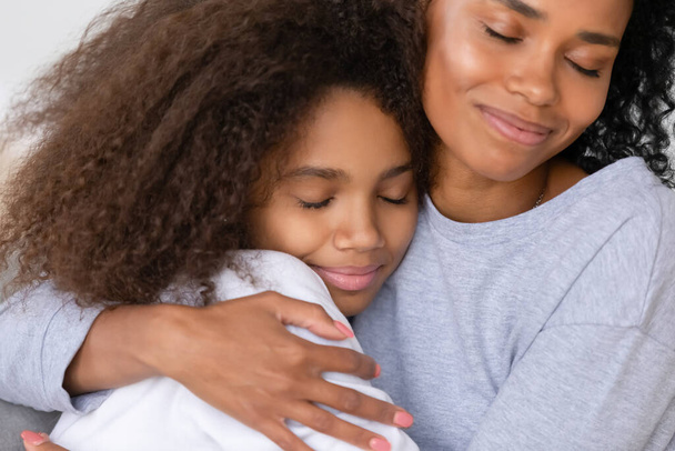 Φροντίδα αφροαμερικανή ανύπαντρη μητέρα αγκαλιάζει έφηβη κόρη, έννοια της μητρότητας - Φωτογραφία, εικόνα