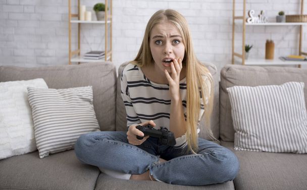 Shocked girl with joystick got stuck during video game - Foto, Bild