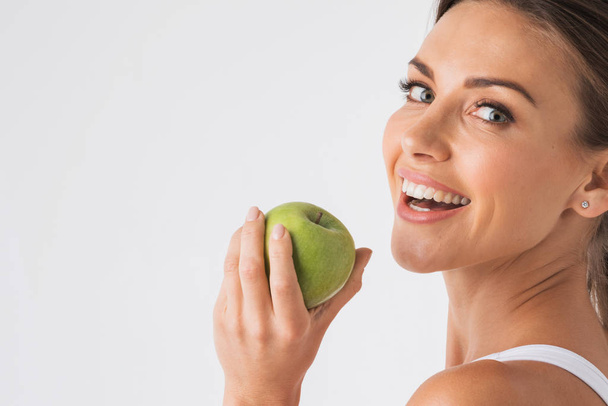 Young beauty woman with green apple on white background - Foto, afbeelding