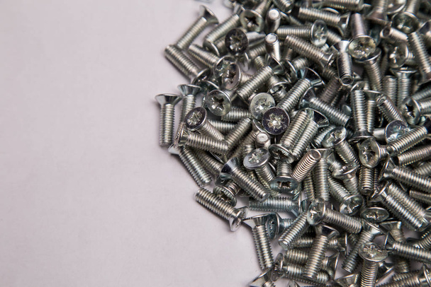 M6 metalen schroeven gegalvaniseerd wit in bulk closeup in de studio - Foto, afbeelding