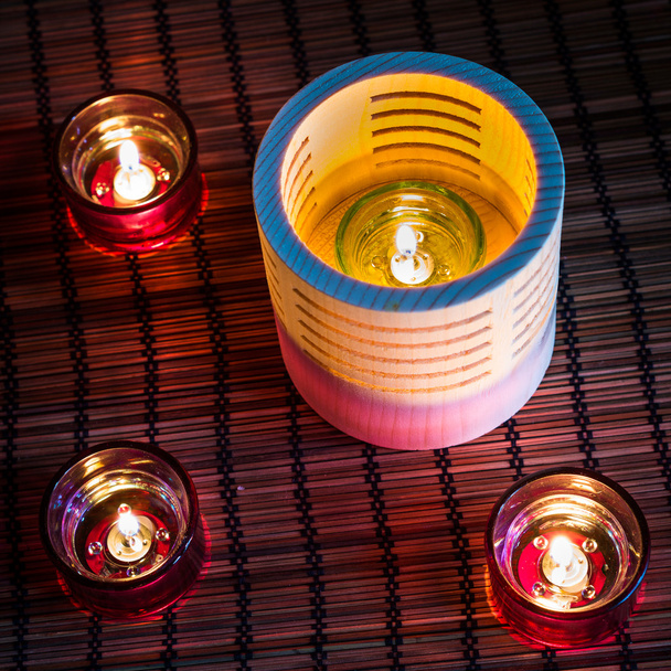 Velas de chá em madeira e vidro em pé no tapete de junco
 - Foto, Imagem