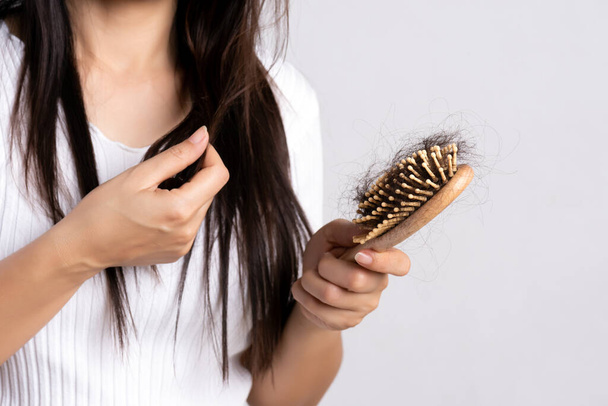 Healthy concept. Woman show her brush with damaged long loss hair and looking at her hair. - Foto, Bild