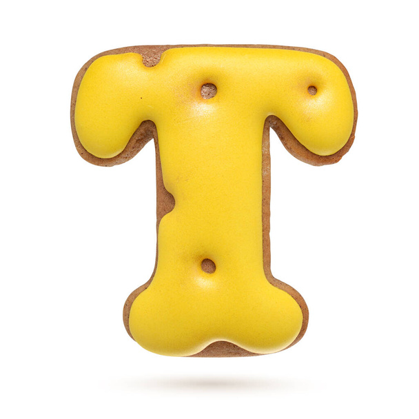 Capital letter T yellow homemade gingerbread biscuit isolated on white background. - Photo, Image