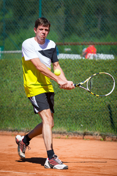 beidhändige Rückhand eines Tennisspielers auf Sandplatz - Foto, Bild