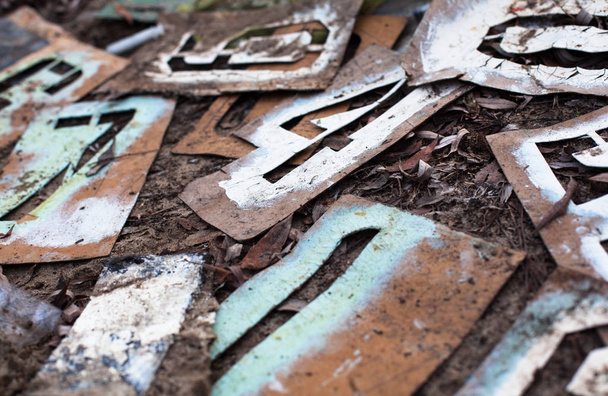 Oude metalen stencils met verschillende cijfers op de grond. - Foto, afbeelding