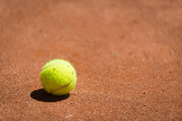 žlutá tenisák na oranžový písek - Fotografie, Obrázek