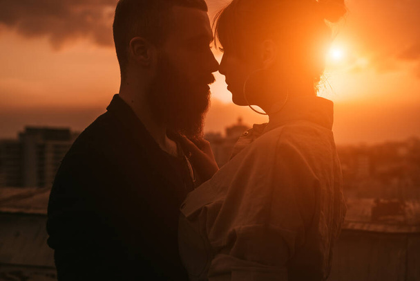 Sensual romantic couple kissing on rooftop at sunset - Fotografie, Obrázek