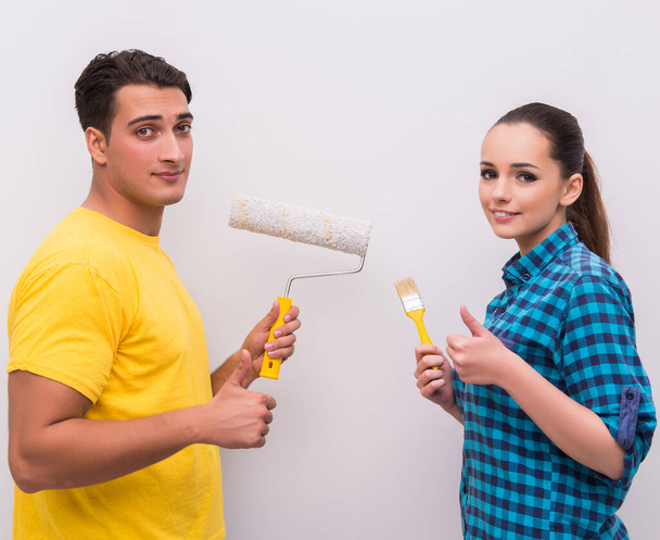 Young couple painting wall at home - Foto, afbeelding