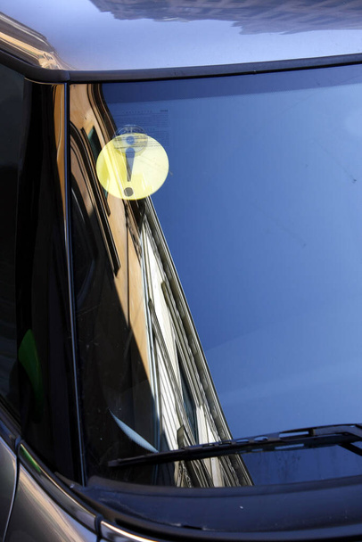 Dettaglio parabrezza auto con cartello giallo per principianti. Edificio riflesso nel finestrino dell'auto
. - Foto, immagini