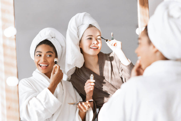 Namoradas em roupões de banho se preparando para a festa, colocando maquiagem
 - Foto, Imagem