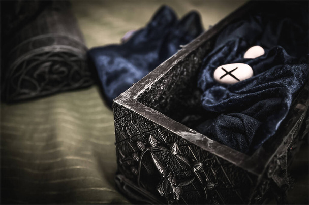 Closeup de pedras runa mística oculta em seda de veludo azul em uma caixa oculta para um destino psíquico pagão ritual de leitura - Conceito de sobrenatural, bruxaria, destino e adivinhação mística
. - Foto, Imagem