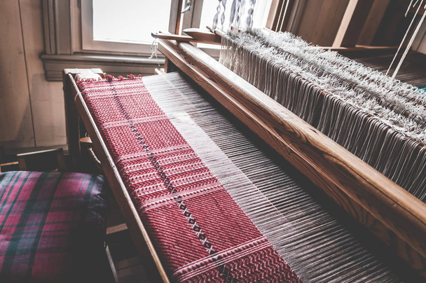 El tradicional telar de tejido vintage antiguo como herramienta de fabricación artesanal profesional para la producción de tejidos hechos a mano en un taller textil
. - Foto, imagen