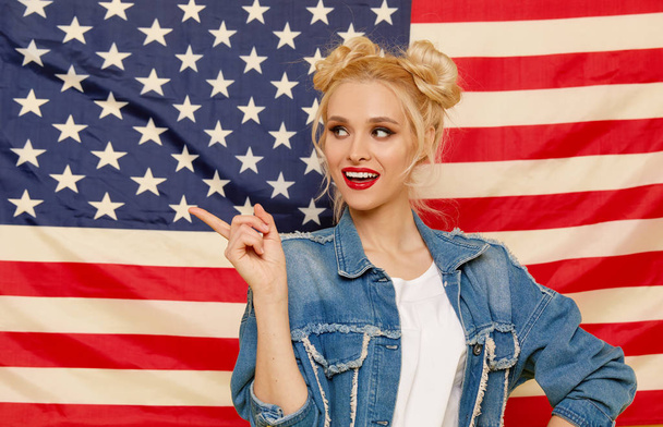 American girl. Portrait of Happy of young surprised woman on USA flag  background. Funny human face. Patriotism concept - 写真・画像